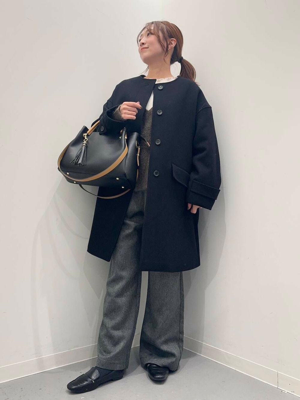 ブラック系のローファー、ブラック系のトートバッグ、ブラック系のその他アウターを着用したレディースの冬コーディネートの2枚目の写真