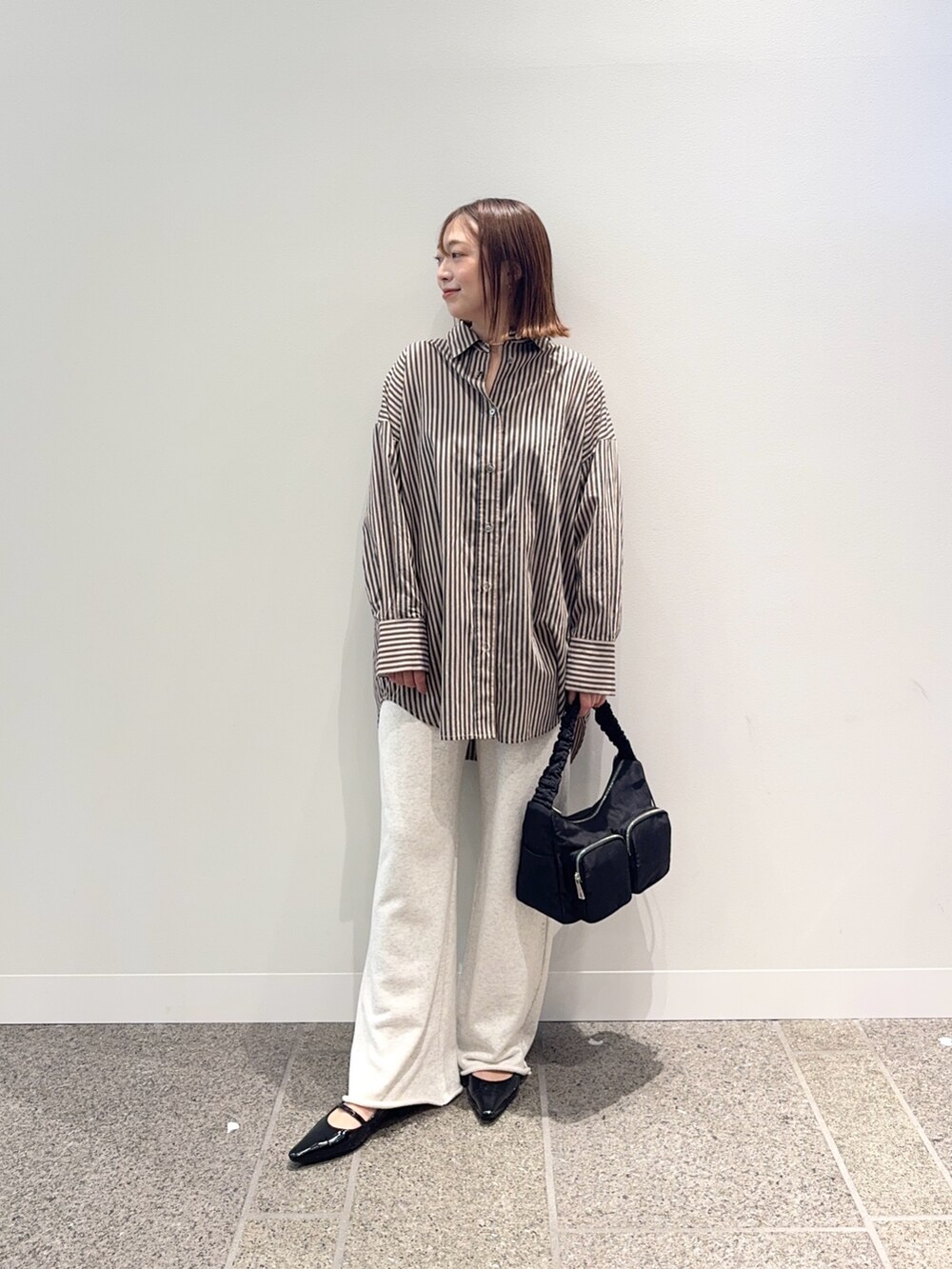 レッド系のシャツ/ブラウス、ベージュ系のその他パンツ、ブラック系のショルダーバッグを着用したレディースの秋コーディネートの2枚目の写真