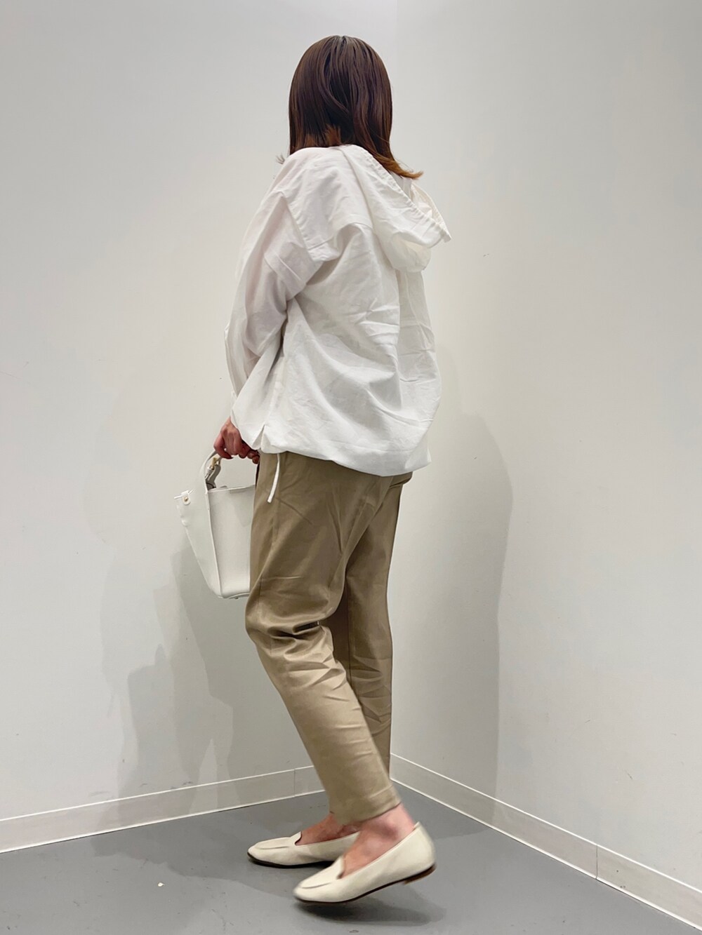 ホワイト系のパーカー、ベージュ系のその他パンツ、ホワイト系のトートバッグを着用したレディースの春コーディネートの4枚目の写真