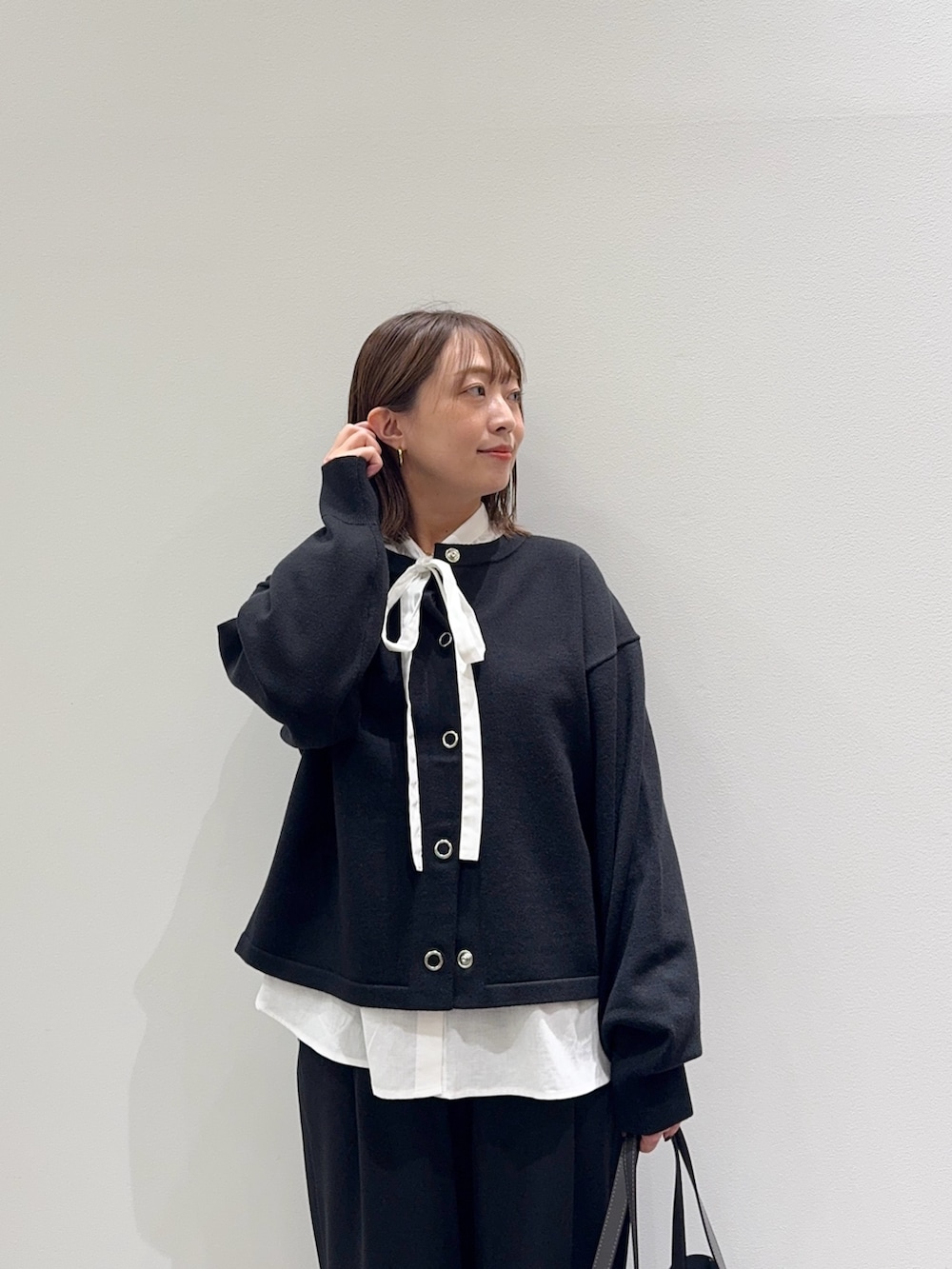 ブラック系のカーディガン/ボレロ、ホワイト系のシャツ/ブラウス、ブラック系のその他パンツを着用したレディースの秋コーディネートの2枚目の写真