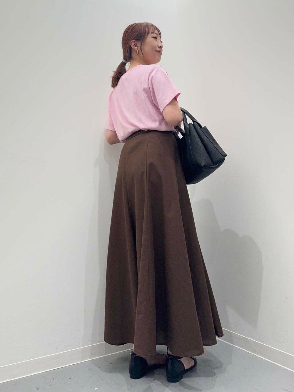 ブラック系のトートバッグ、ブラック系のサンダル、ブラウン系のスカートを着用したレディースの夏コーディネートの4枚目の写真