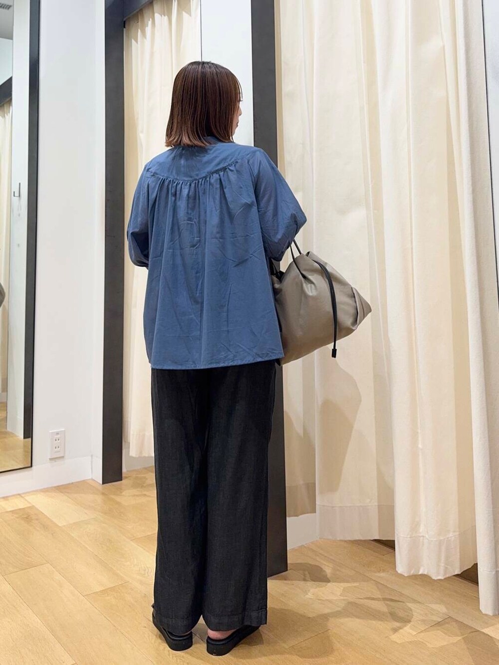 ベージュ系のショルダーバッグ、ブラック系のサンダル、ブラック系のデニムパンツを着用したレディースの夏コーディネートの4枚目の写真