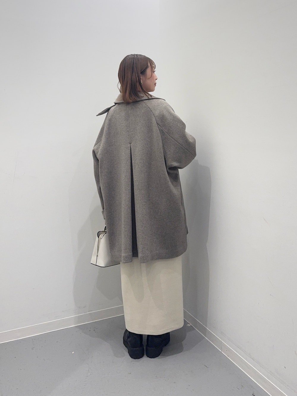 ベージュ系のその他アウター、ベージュ系のワンピース、ホワイト系のハンドバッグを着用したレディースの冬コーディネートの4枚目の写真