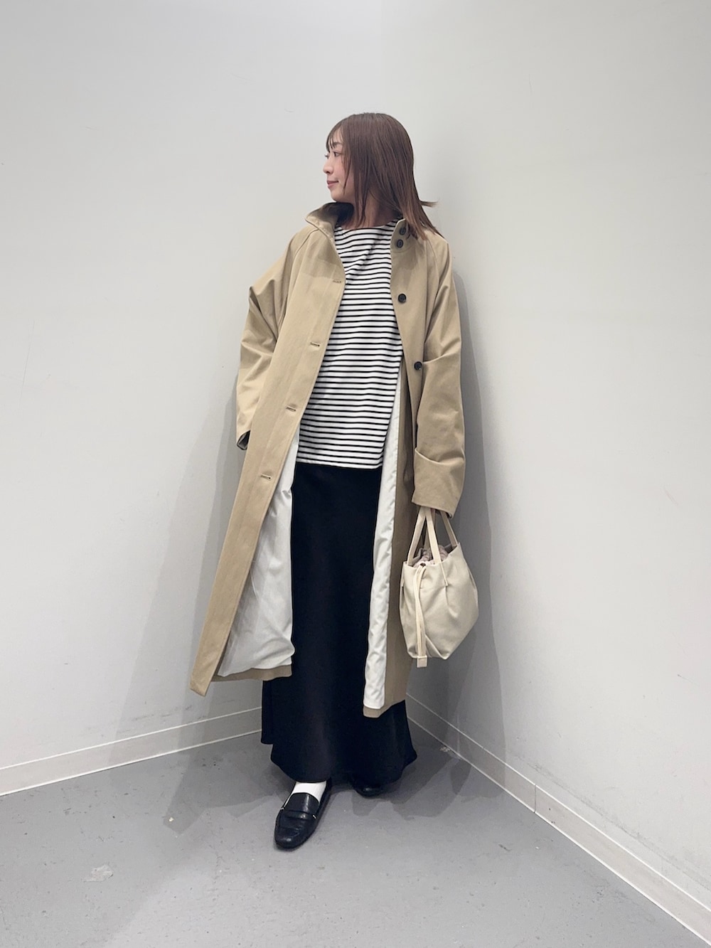 ベージュ系のその他アウター、ホワイト系のTシャツ/カットソー、ブラック系のスカートを着用したレディースの春コーディネートの2枚目の写真