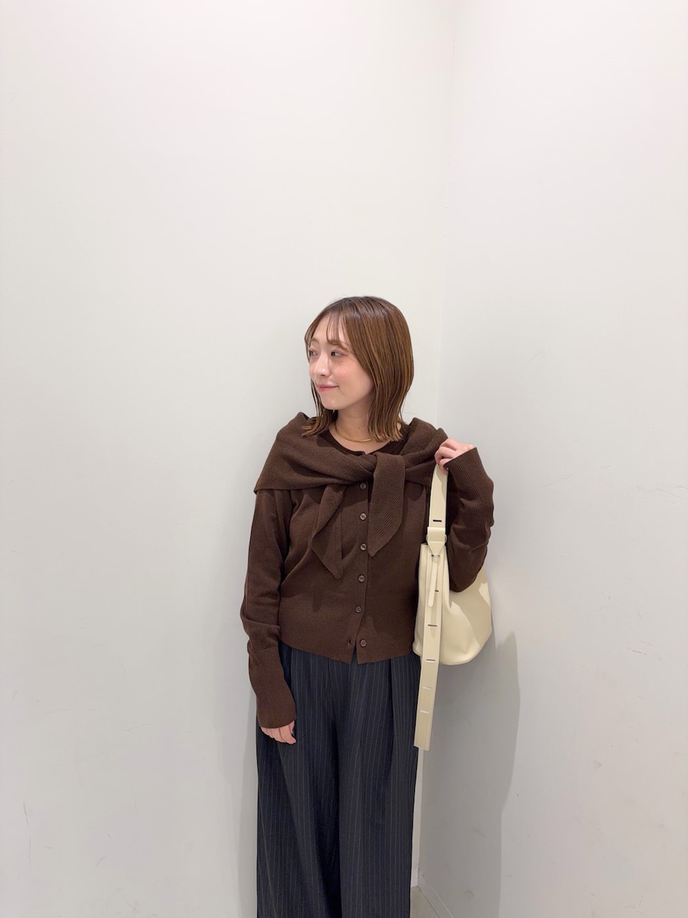 ブラウン系のカーディガン/ボレロ、グレー系のその他パンツ、ベージュ系のショルダーバッグを着用したレディースの秋コーディネートの8枚目の写真