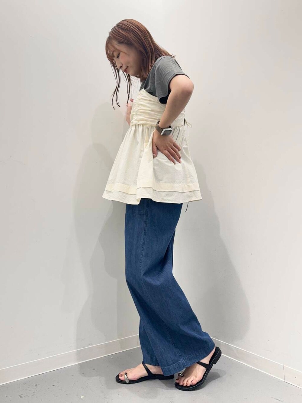 ブラック系のトートバッグ、ブルー系のデニムパンツ、ブラック系のサンダルを着用したレディースの夏コーディネートの3枚目の写真