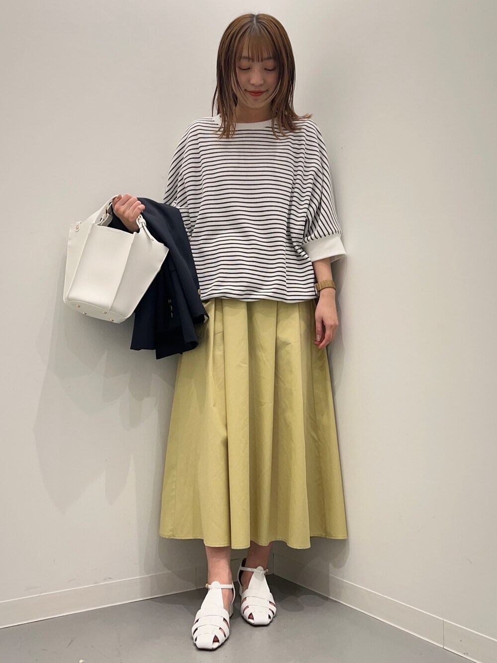 ブルー系のその他アウター、ホワイト系のTシャツ/カットソー、イエロー系のスカートを着用したレディースの春コーディネートの6枚目の写真