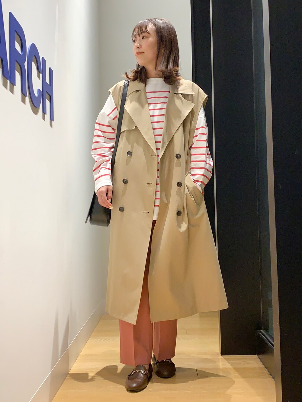 ベージュ系のベスト、ピンク系のTシャツ/カットソー、ブラウン系のローファーを着用したレディースの春コーディネートの4枚目の写真