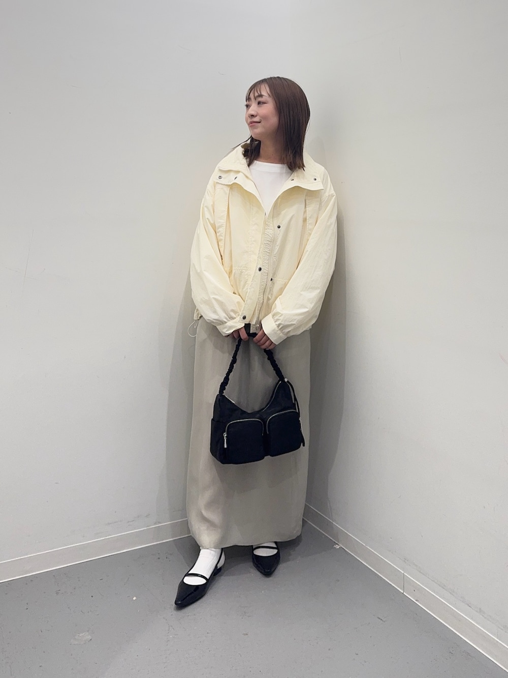 ホワイト系のナイロンジャケット、ベージュ系のスカート、ホワイト系のTシャツ/カットソーを着用したレディースの春コーディネートの4枚目の写真