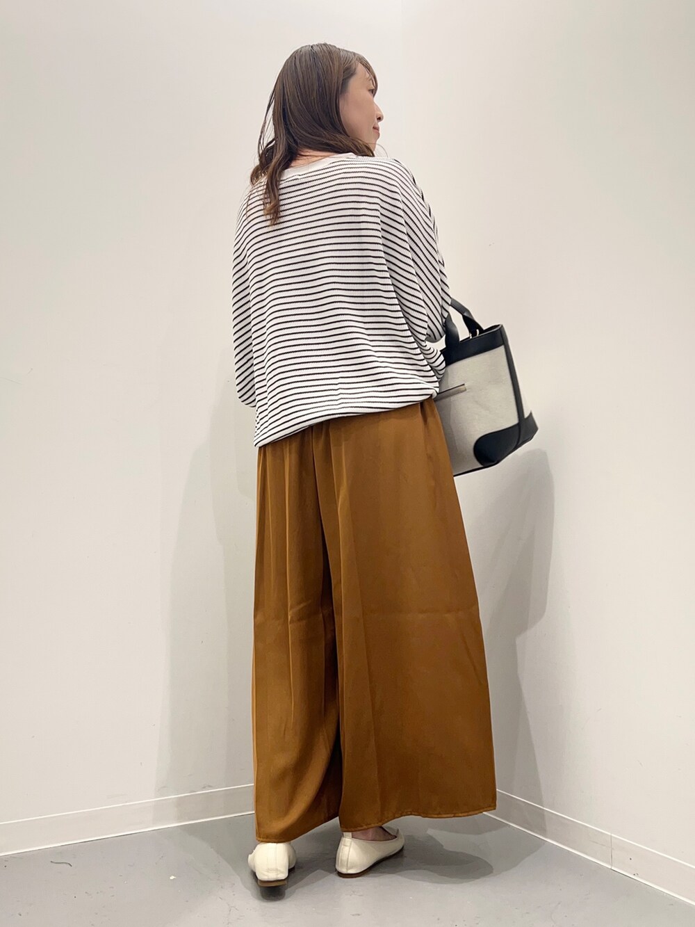 ホワイト系のTシャツ/カットソー、イエロー系のその他パンツ、ブラック系のトートバッグを着用したレディースの夏コーディネートの5枚目の写真