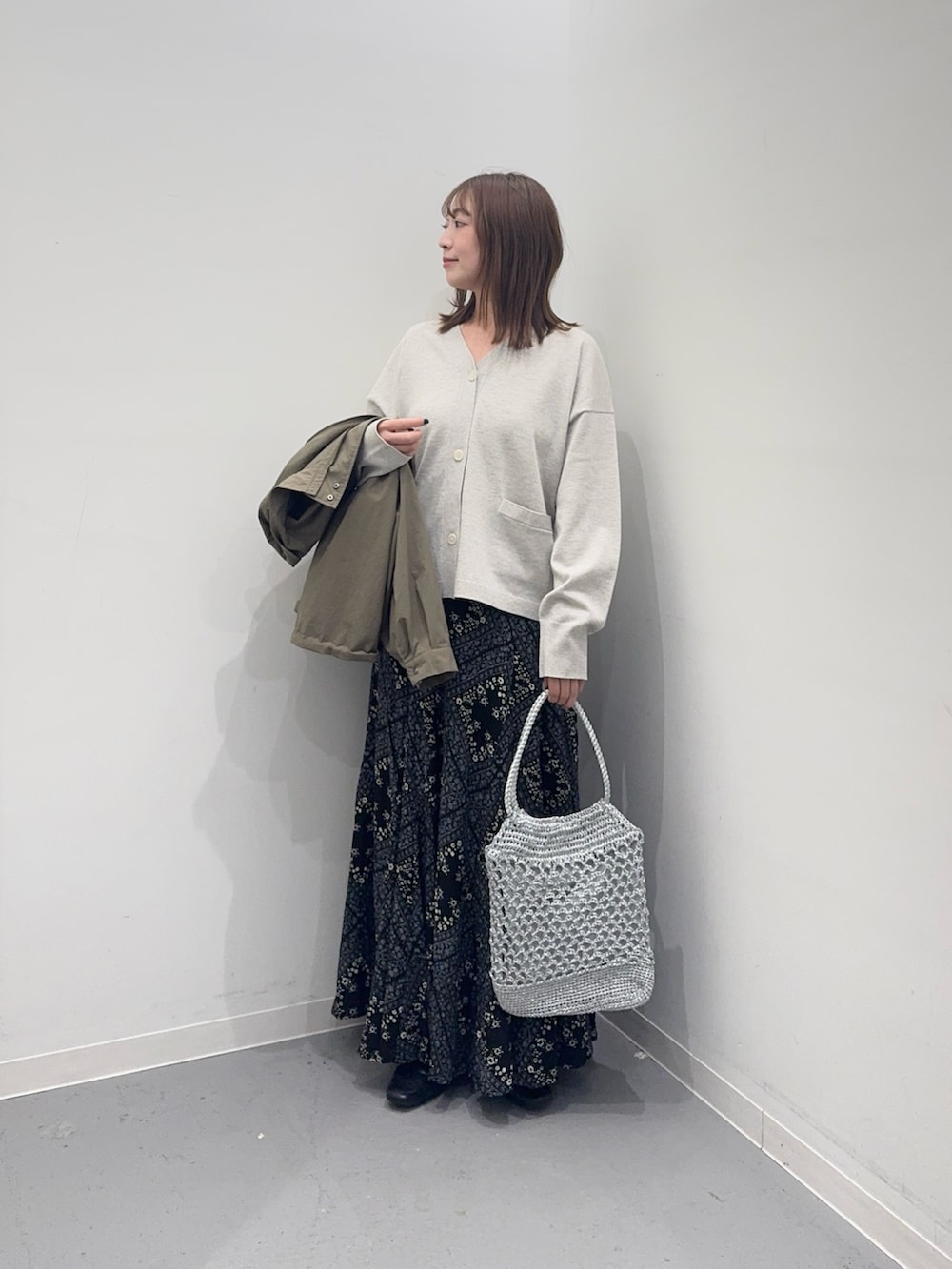 ベージュ系のカーディガン/ボレロ、グリーン系のブルゾン、ブラック系のスカートを着用したレディースの春コーディネートの5枚目の写真