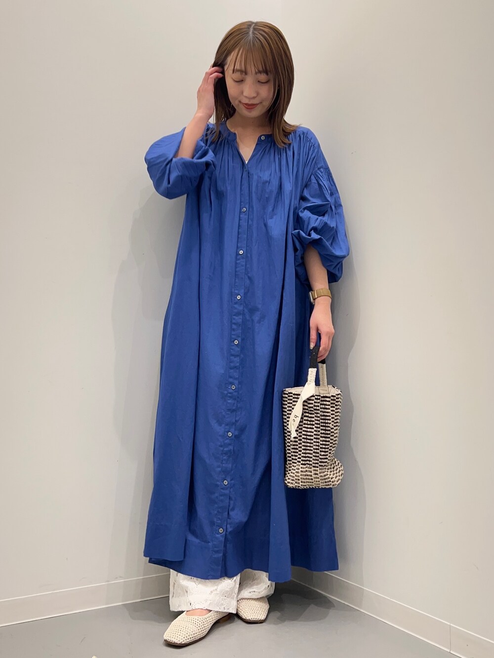 ブルー系のワンピース、ホワイト系のその他パンツ、ブラック系のショルダーバッグを着用したレディースの春コーディネートの2枚目の写真