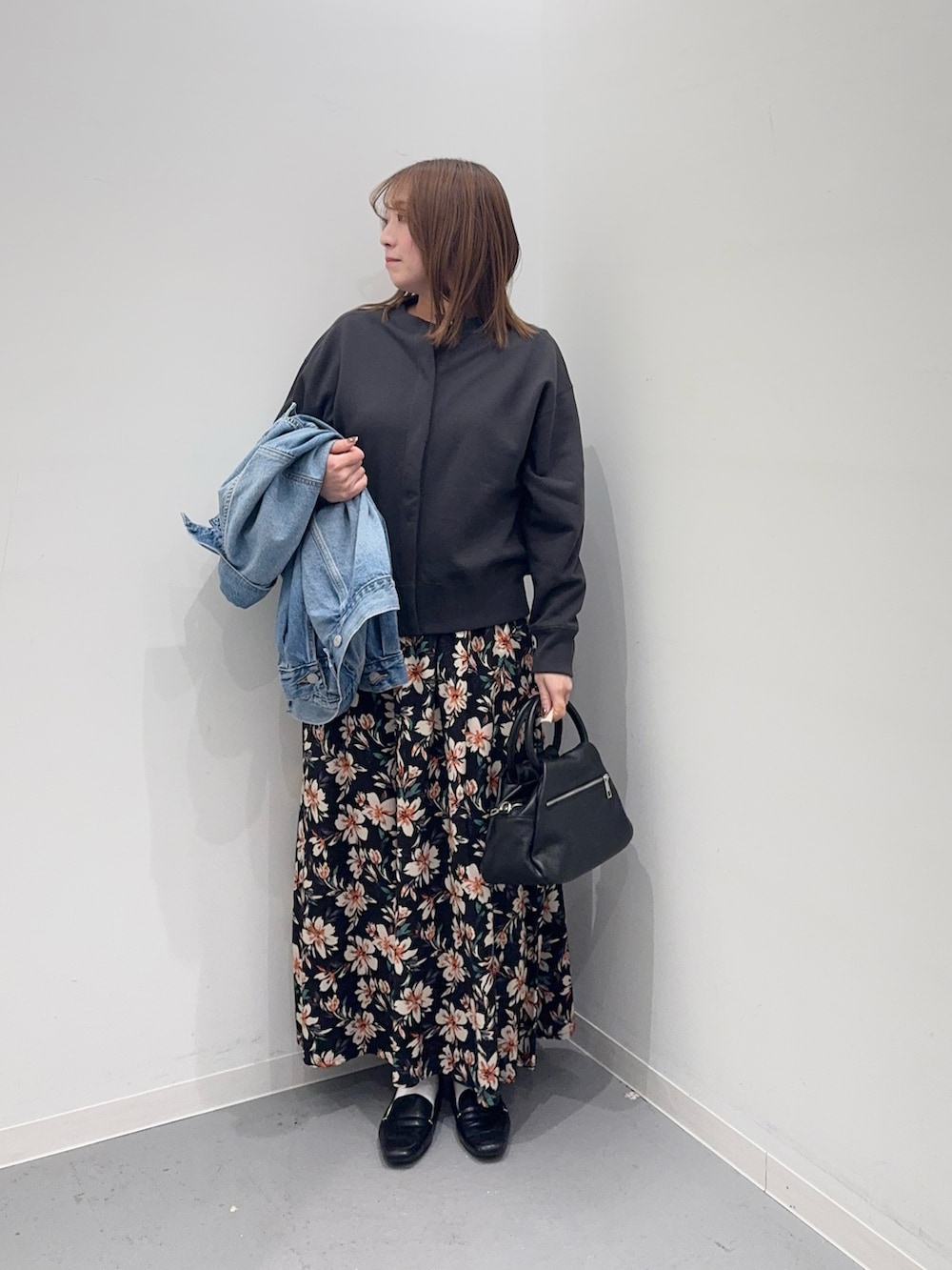 ブルー系のデニムジャケット、グレー系のカーディガン/ボレロ、ブラック系のスカートを着用したレディースの冬コーディネートの5枚目の写真