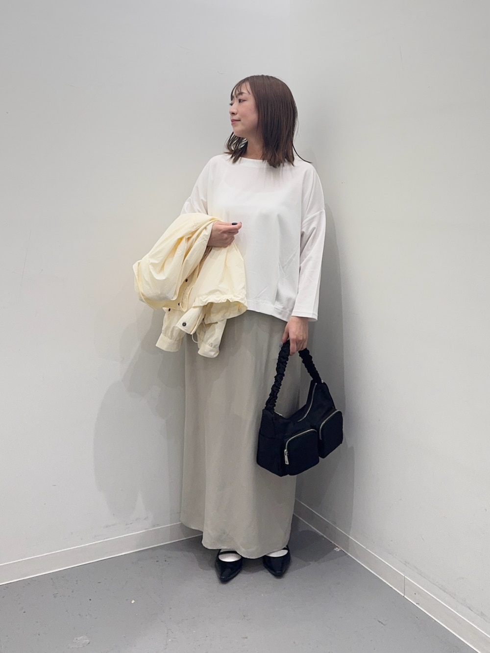 ホワイト系のナイロンジャケット、ベージュ系のスカート、ホワイト系のTシャツ/カットソーを着用したレディースの春コーディネートの5枚目の写真