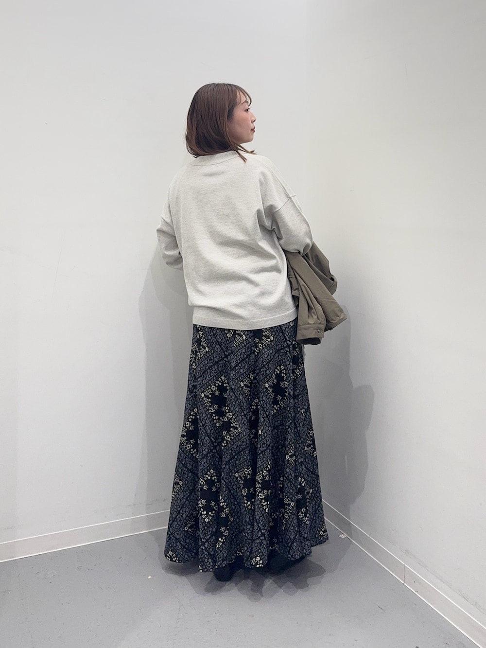 ベージュ系のカーディガン/ボレロ、グリーン系のブルゾン、ブラック系のスカートを着用したレディースの春コーディネートの6枚目の写真