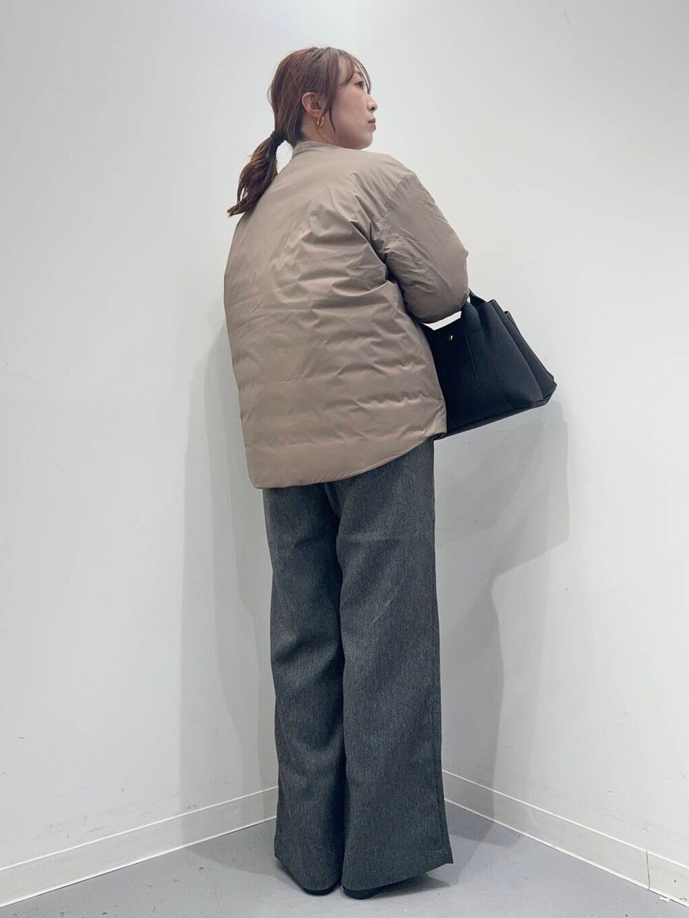 グレー系のその他パンツ、ベージュ系のニット/セーター、ブラウン系のダウンジャケット/コートを着用したレディースの冬コーディネートの3枚目の写真