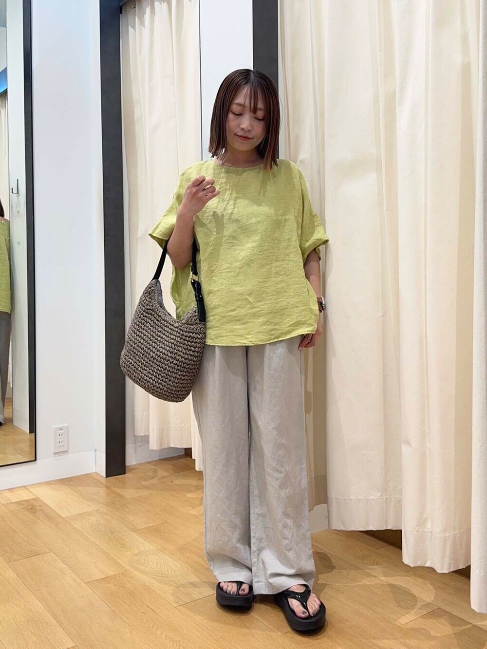 グレー系のトートバッグ、ブラック系のサンダル、イエロー系のシャツ/ブラウスを着用したレディースの夏コーディネートの2枚目の写真