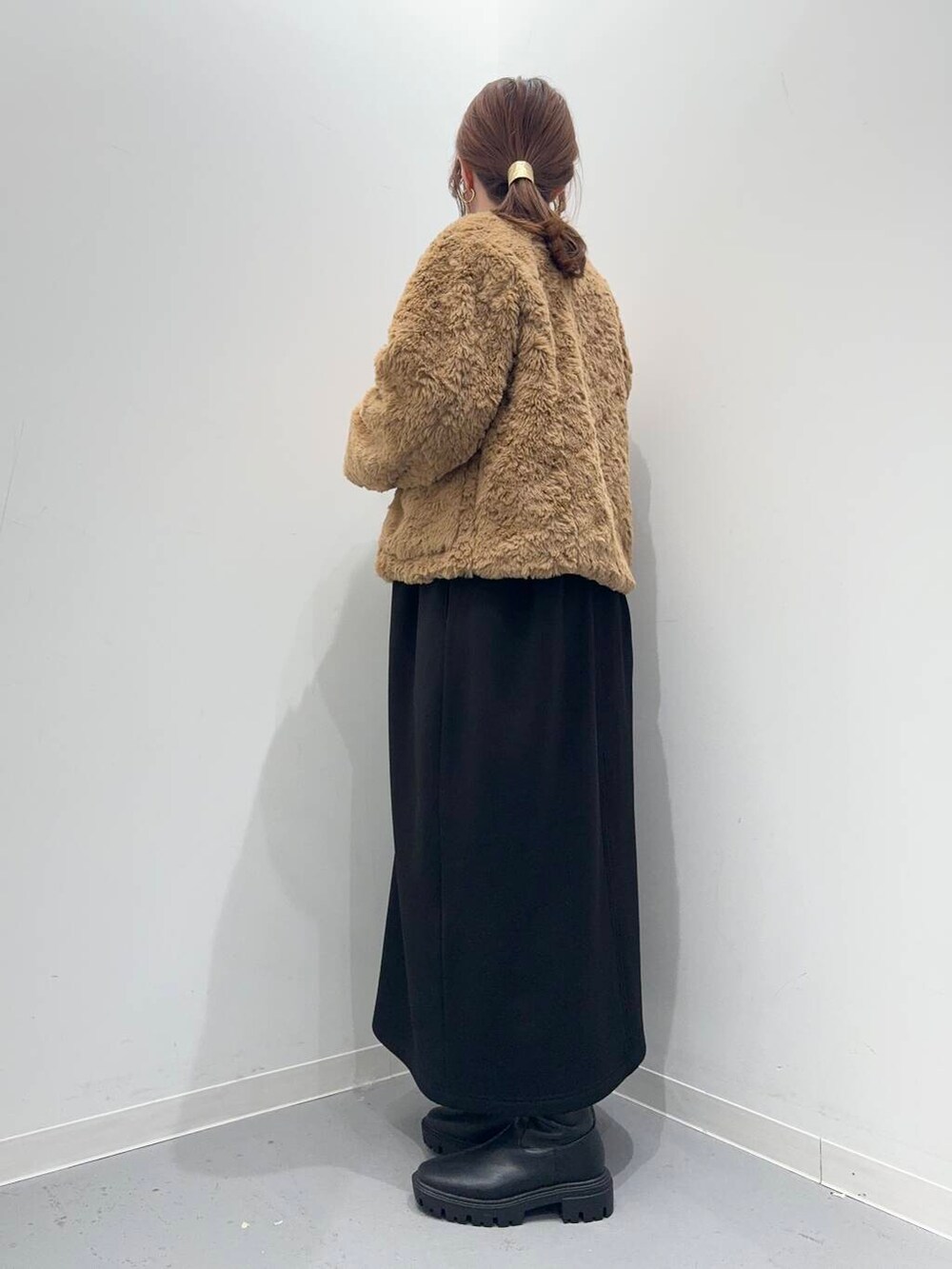 ブラック系のトートバッグ、ブラック系のブーツ、イエロー系のその他アウターを着用したレディースの冬コーディネートの3枚目の写真