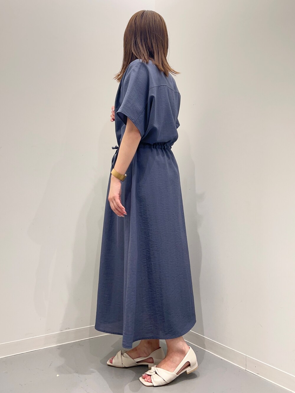 ブルー系のワンピース、ホワイト系のパンプス、ブラック系のトートバッグを着用したレディースの春コーディネートの3枚目の写真