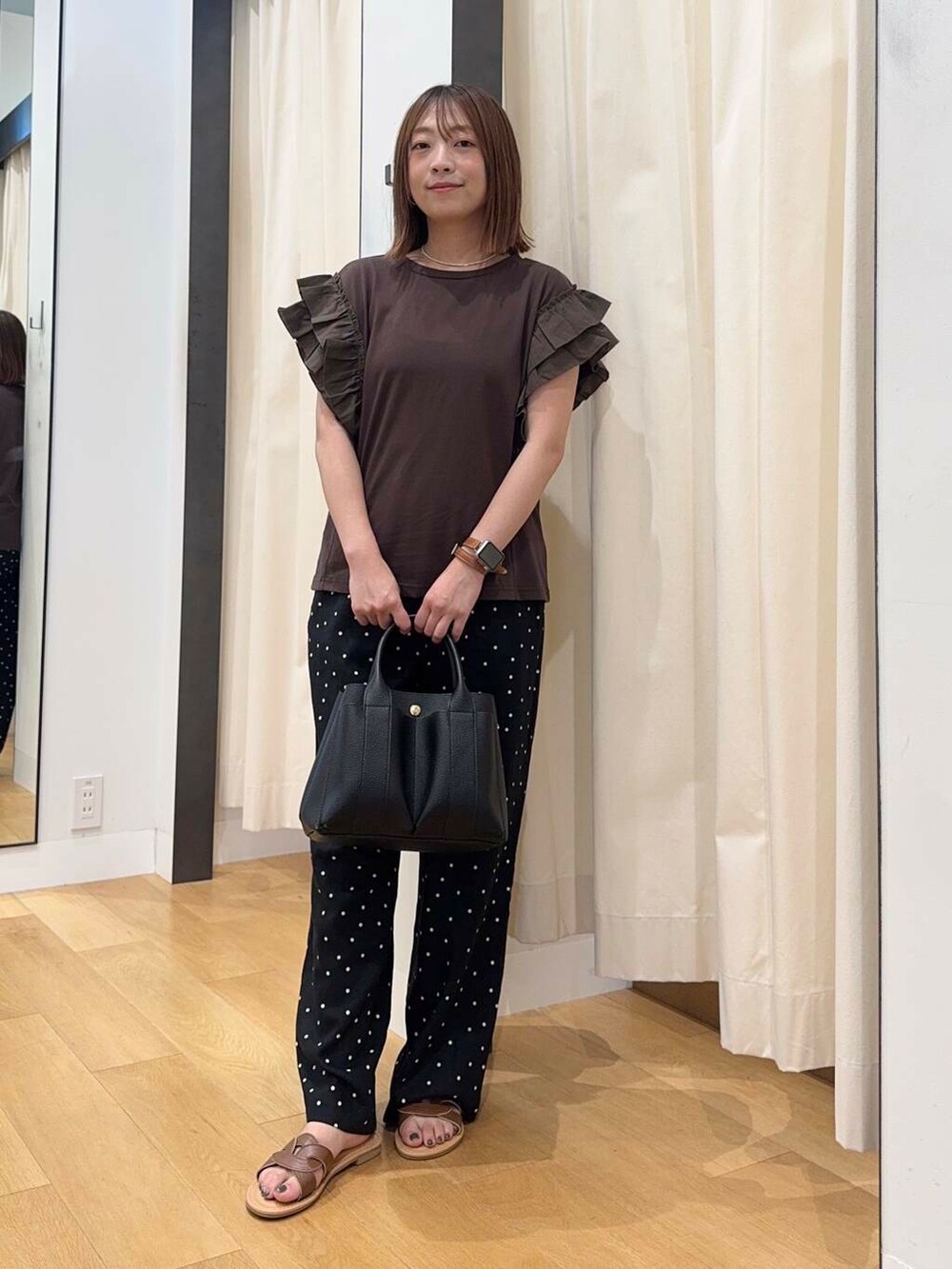 ブラック系のトートバッグ、ブラウン系のサンダル、ブラウン系のTシャツ/カットソーを着用したレディースの夏コーディネートの5枚目の写真