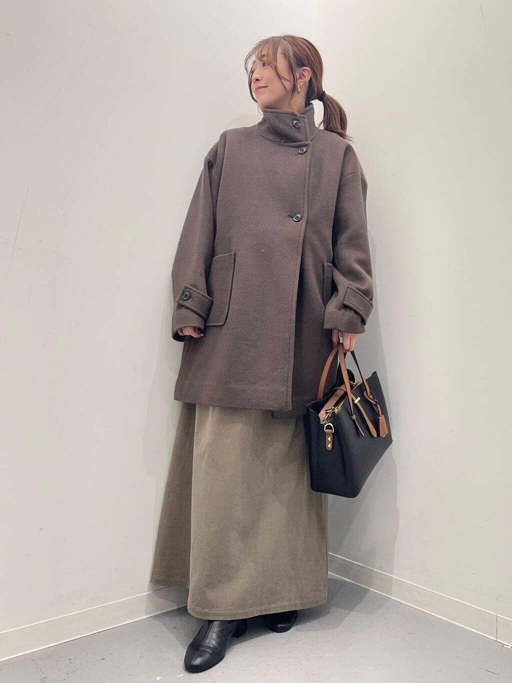 ブラック系のブーツ、ブラック系のトートバッグ、ブラウン系のその他アウターを着用したレディースの冬コーディネートの4枚目の写真