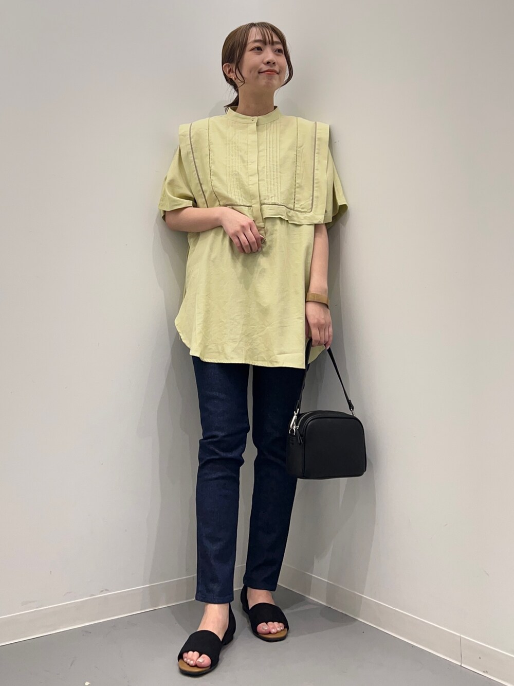 イエロー系のシャツ/ブラウス、ブルー系のデニムパンツ、ブラック系のショルダーバッグを着用したレディースの春コーディネートの4枚目の写真