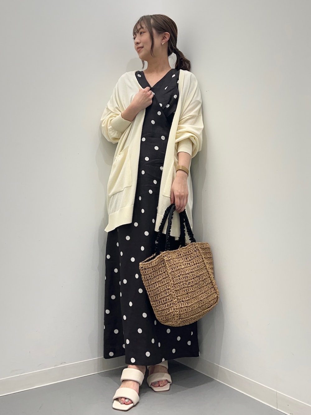ブラック系のワンピース、ホワイト系のカーディガン/ボレロ、ベージュ系のかごバッグを着用したレディースの夏コーディネートの5枚目の写真
