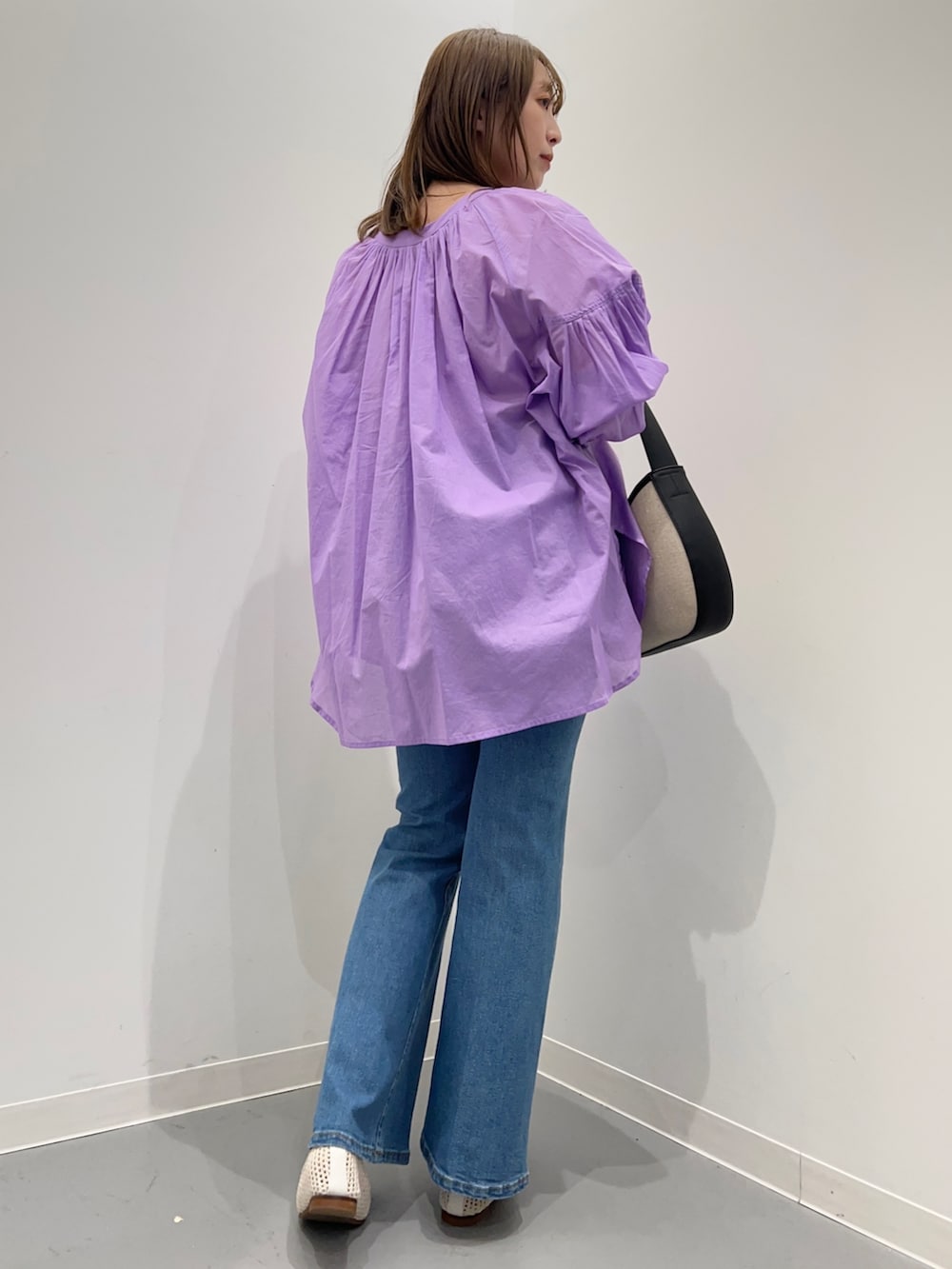 パープル系のシャツ/ブラウス、ブルー系のデニムパンツ、ブラック系のハンドバッグを着用したレディースの春コーディネートの4枚目の写真