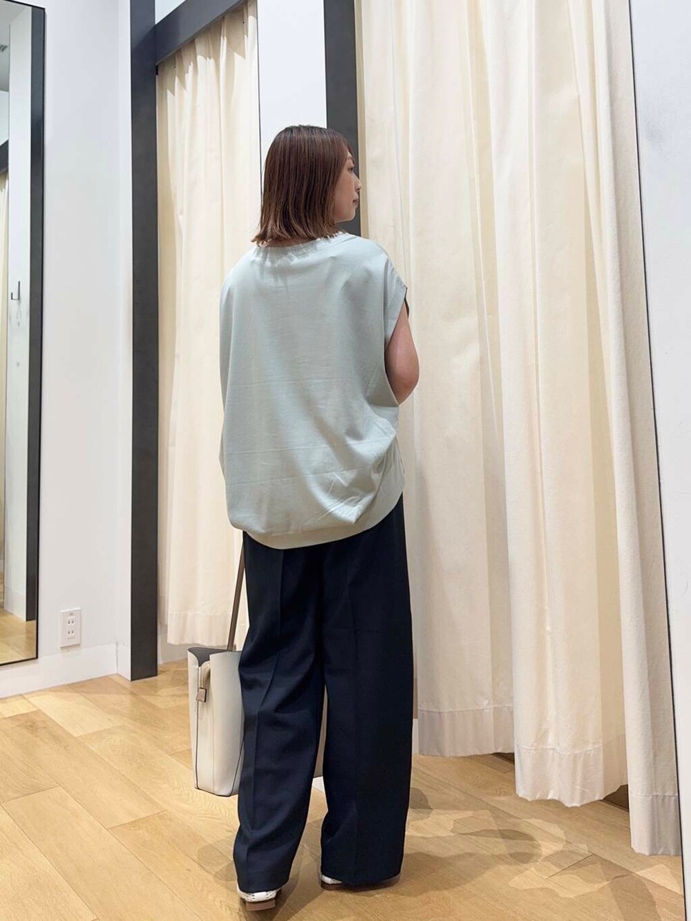 ホワイト系のトートバッグ、グリーン系のTシャツ/カットソー、ホワイト系のバレエシューズを着用したレディースの夏コーディネートの4枚目の写真