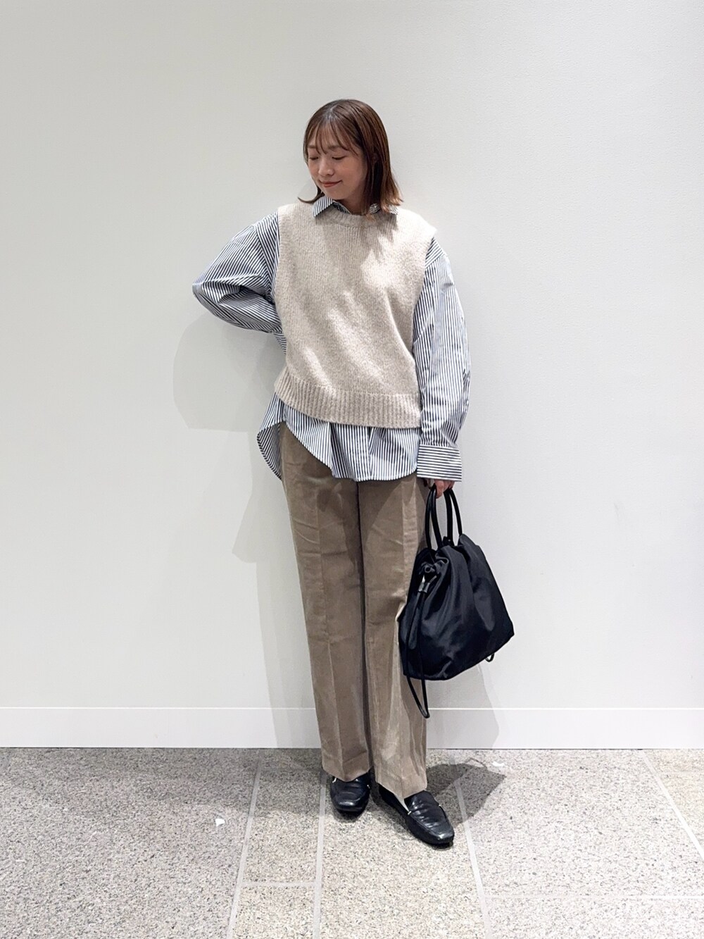 ブルー系のシャツ/ブラウス、ベージュ系のその他パンツ、ブラック系のローファーを着用したレディースの秋コーディネートの2枚目の写真