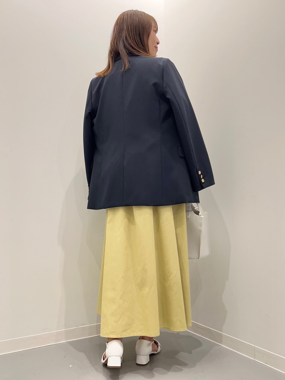 ブルー系のその他アウター、ホワイト系のTシャツ/カットソー、イエロー系のスカートを着用したレディースの春コーディネートの4枚目の写真