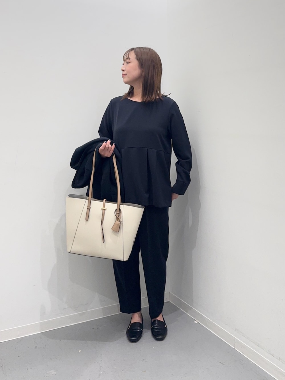 ブルー系のセットアップ、ブルー系のスーツジャケット、ホワイト系のトートバッグを着用したレディースの冬コーディネートの5枚目の写真