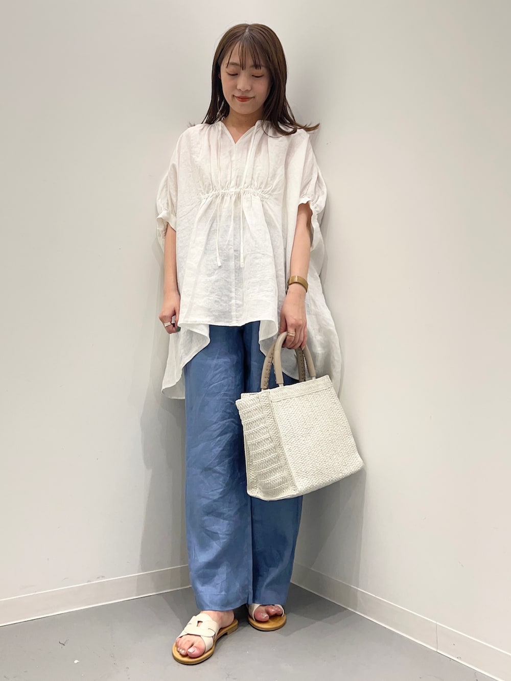 ホワイト系のシャツ/ブラウス、ブルー系のその他パンツ、ベージュ系のトートバッグを着用したレディースの夏コーディネートの2枚目の写真