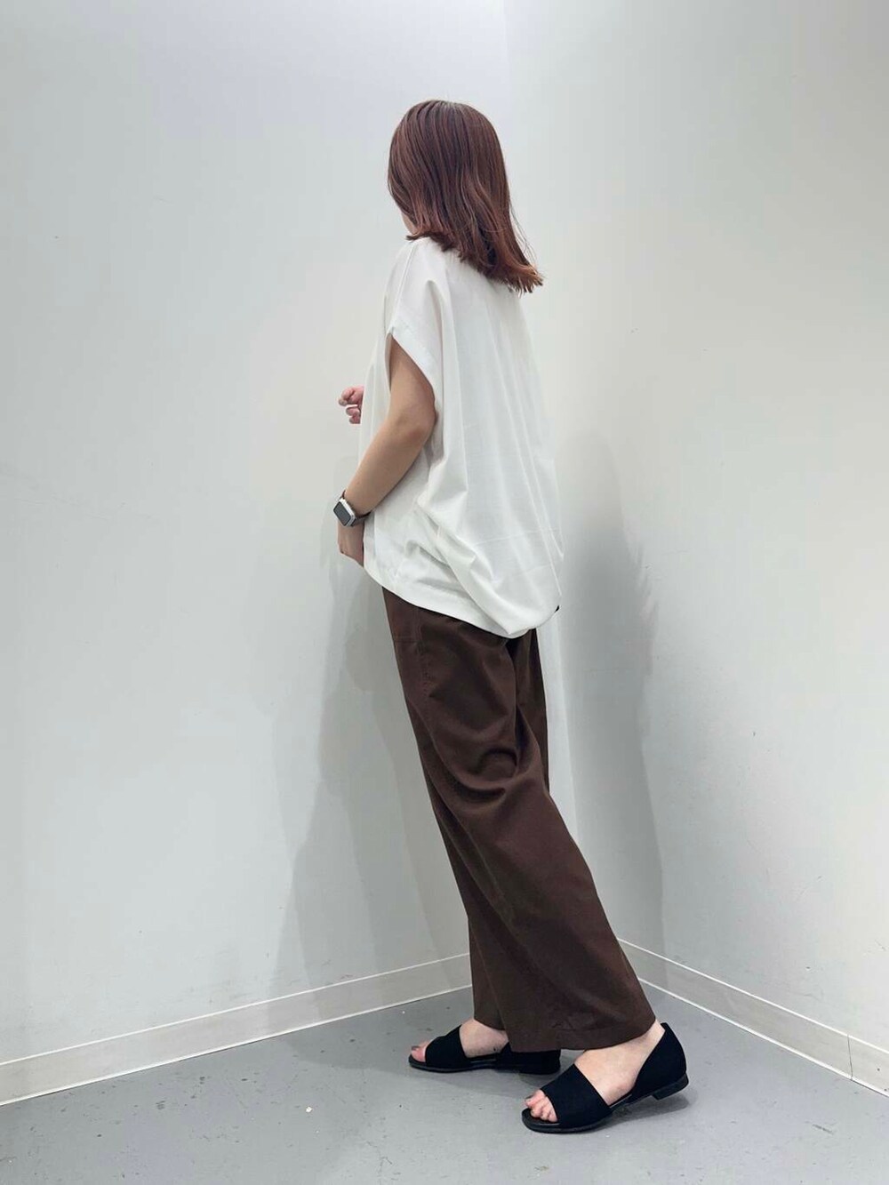 ブラック系のトートバッグ、ホワイト系のTシャツ/カットソー、ブラック系のサンダルを着用したレディースの夏コーディネートの2枚目の写真