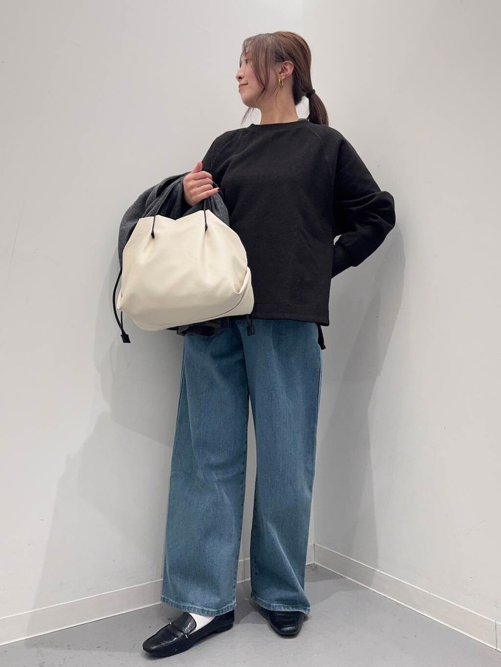 ブラック系のローファー、ホワイト系のショルダーバッグ、グレー系のトレンチコートを着用したレディースの冬コーディネートの5枚目の写真