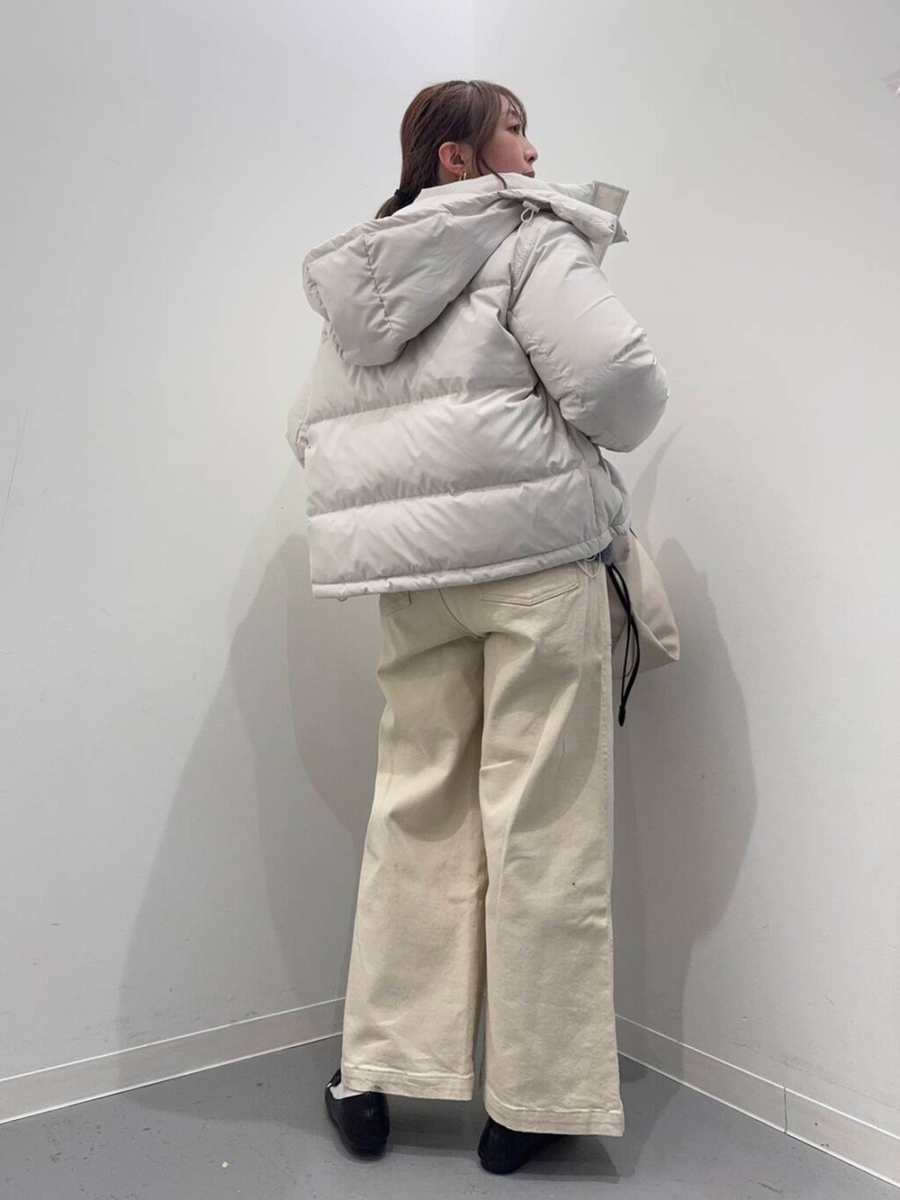 ブラック系のローファー、ホワイト系のショルダーバッグ、ホワイト系のダウンジャケット/コートを着用したレディースの冬コーディネートの3枚目の写真