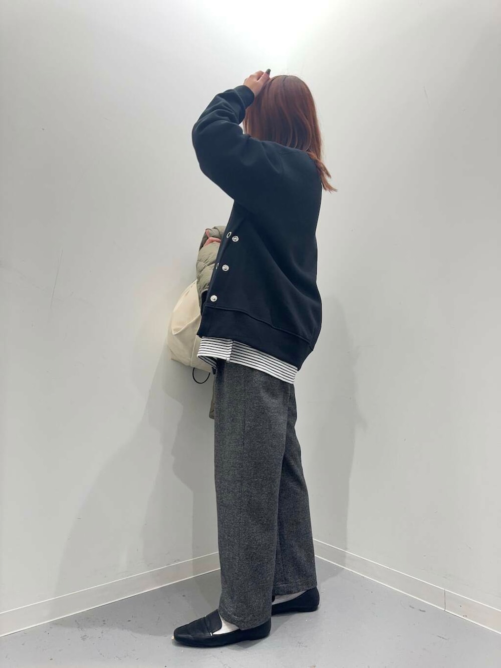 ブラック系のローファー、ホワイト系のショルダーバッグ、グリーン系のダウンジャケット/コートを着用したレディースの秋コーディネートの6枚目の写真