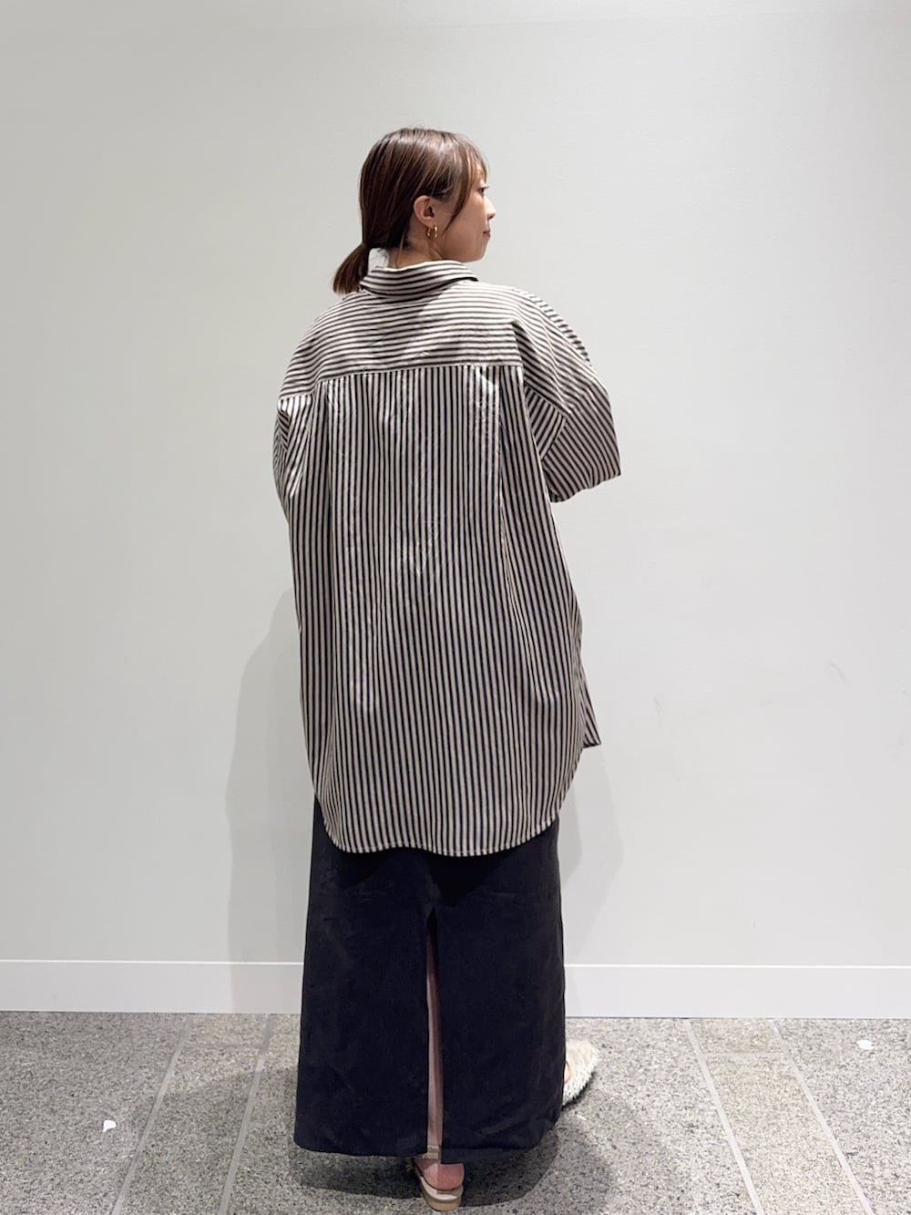 グレー系のシャツ/ブラウス、ブラウン系のスカート、ホワイト系のトートバッグを着用したレディースの秋コーディネートの4枚目の写真