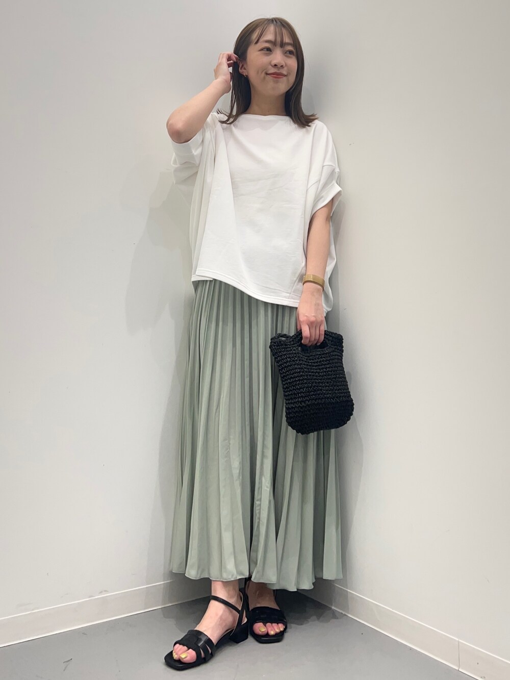 ホワイト系のTシャツ/カットソー、グリーン系のスカートを着用したレディースの春コーディネートの3枚目の写真