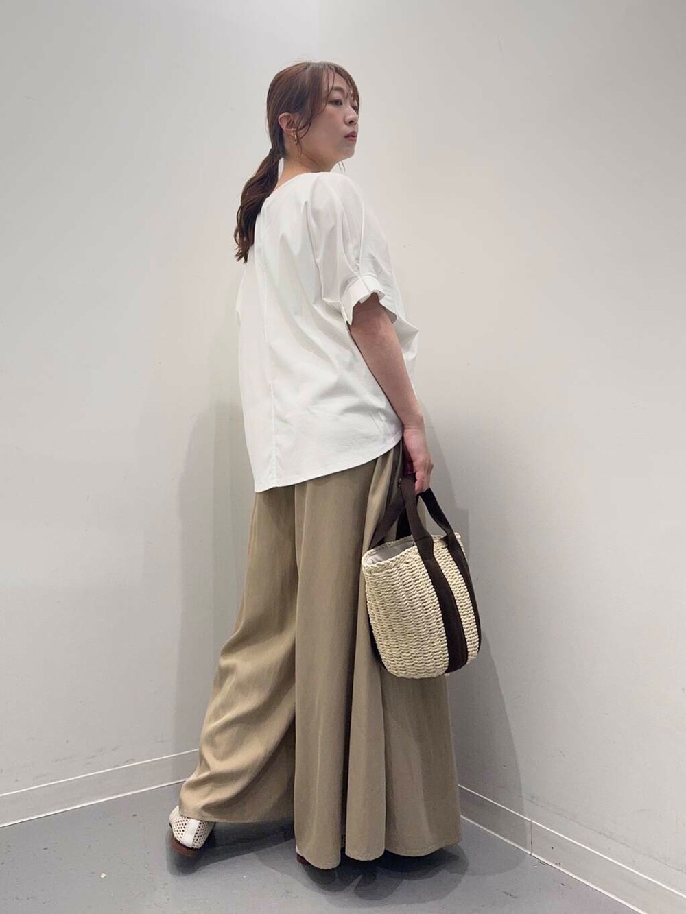 ホワイト系のハンドバッグ、ホワイト系のバレエシューズ、ベージュ系のその他パンツを着用したレディースの春コーディネートの3枚目の写真