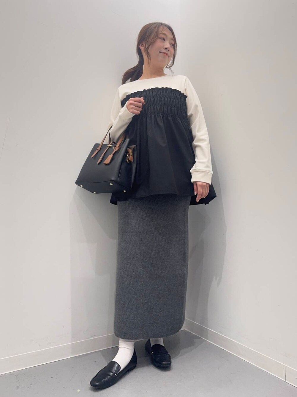 ブラック系のローファー、ブラック系のトートバッグ、ホワイト系のTシャツ/カットソーを着用したレディースの冬コーディネートの5枚目の写真