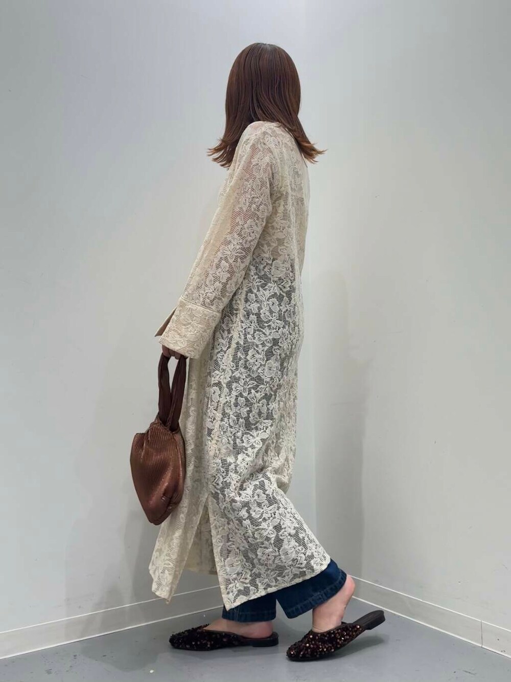 ブラウン系のハンドバッグ、ブルー系のデニムパンツ、ブラウン系のその他シューズを着用したレディースの秋コーディネートの3枚目の写真