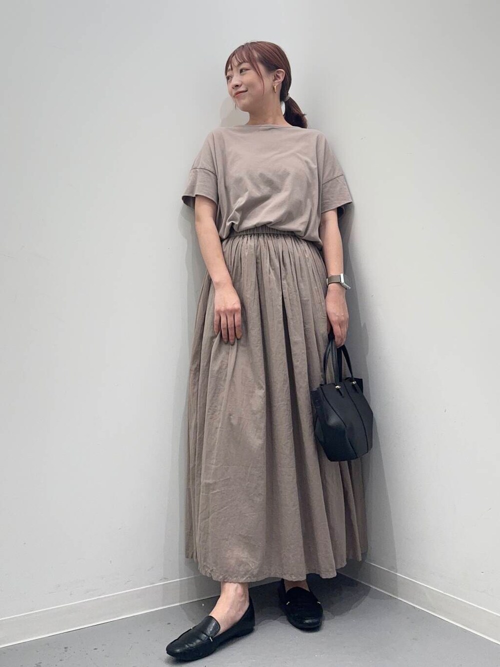 ブラック系のローファー、グレー系のワンピース、ブラック系のショルダーバッグを着用したレディースの夏コーディネートの2枚目の写真