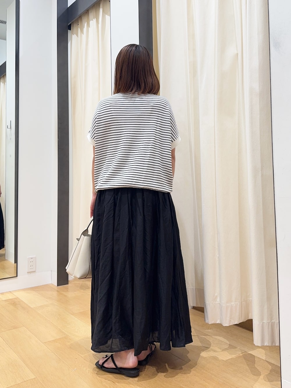 ホワイト系のTシャツ/カットソー、ブラック系のサンダル、ブラック系のスカートを着用したレディースの夏コーディネートの3枚目の写真