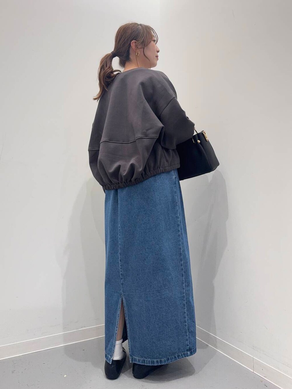 ブラック系のローファー、ブラック系のトートバッグ、ブルー系のワンピースを着用したレディースの春コーディネートの4枚目の写真