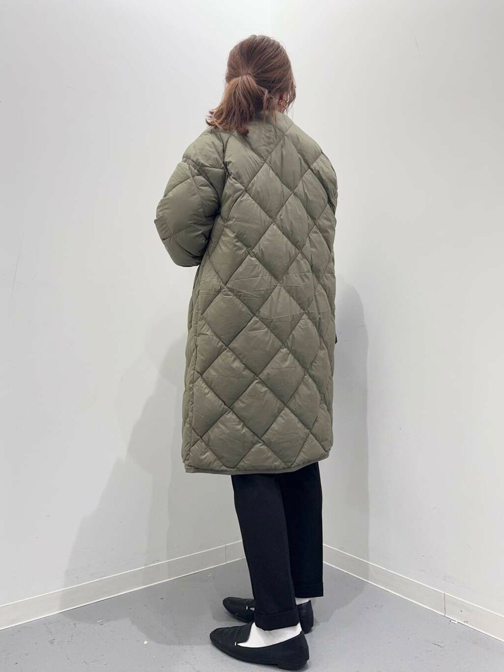 ブラック系のローファー、グリーン系のダウンジャケット/コート、ブルー系のシャツ/ブラウスを着用したレディースの冬コーディネートの3枚目の写真