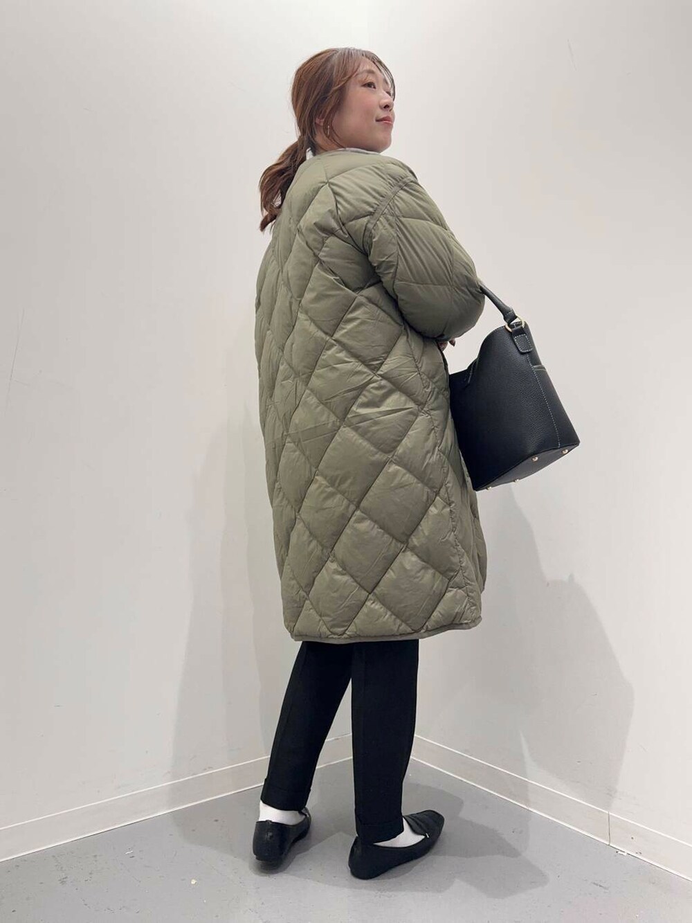 ブラック系のローファー、グリーン系のダウンジャケット/コート、ブルー系のシャツ/ブラウスを着用したレディースの冬コーディネートの4枚目の写真