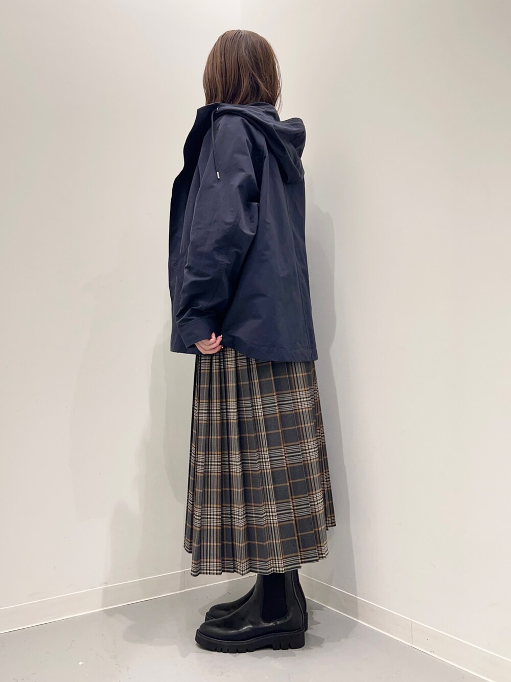 ホワイト系のTシャツ/カットソー、グレー系のスカート、ブルー系のダウンベストを着用したレディースの秋コーディネートの6枚目の写真