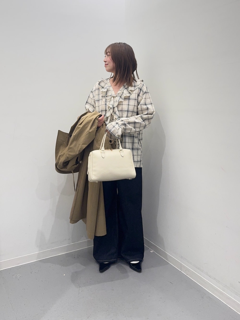 ベージュ系のその他アウター、ブラック系のシャツ/ブラウス、ブルー系のデニムパンツを着用したレディースの春コーディネートの7枚目の写真