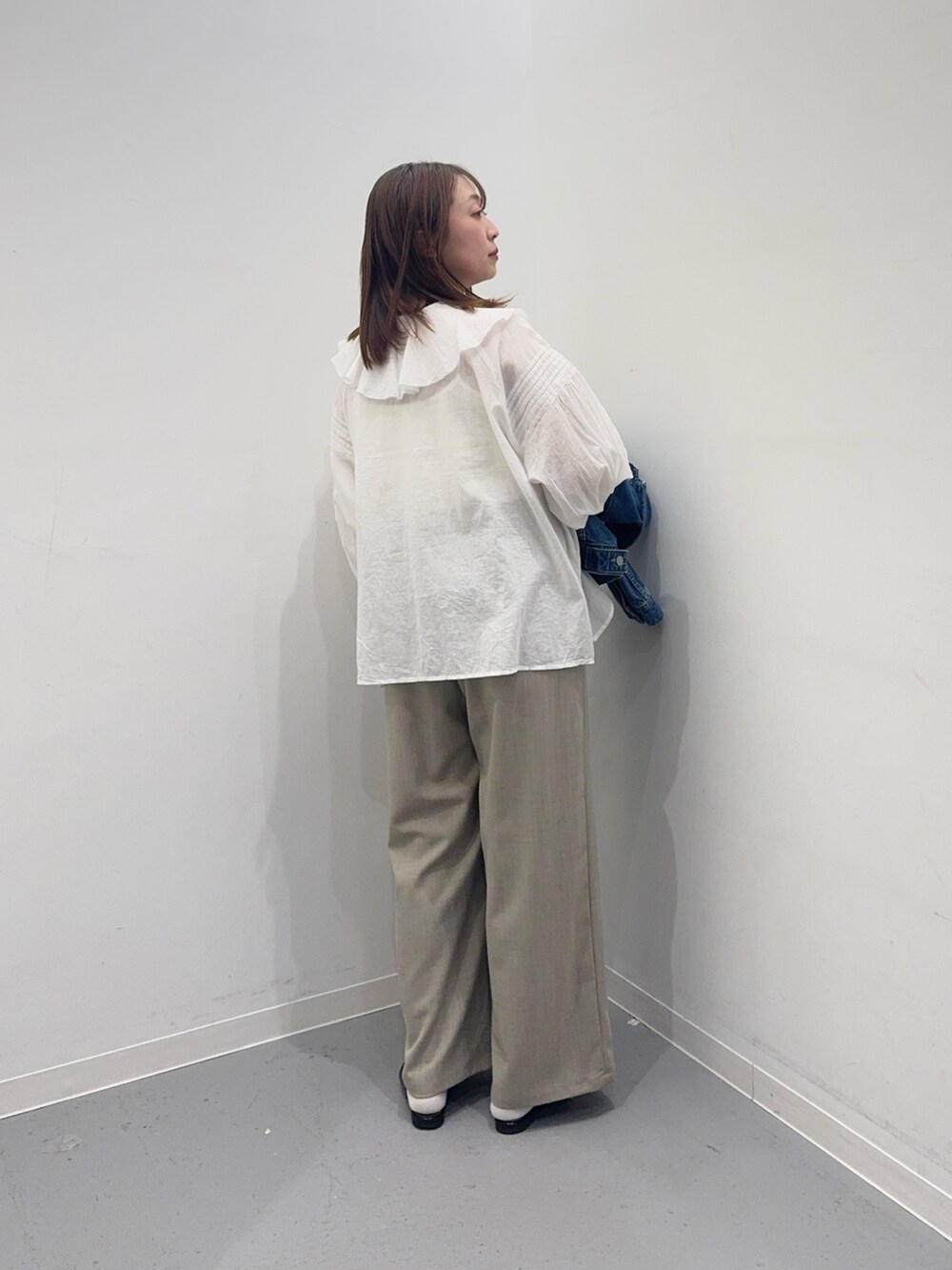 ブルー系のデニムジャケット、ホワイト系のシャツ/ブラウス、ベージュ系のその他パンツを着用したレディースの春コーディネートの7枚目の写真